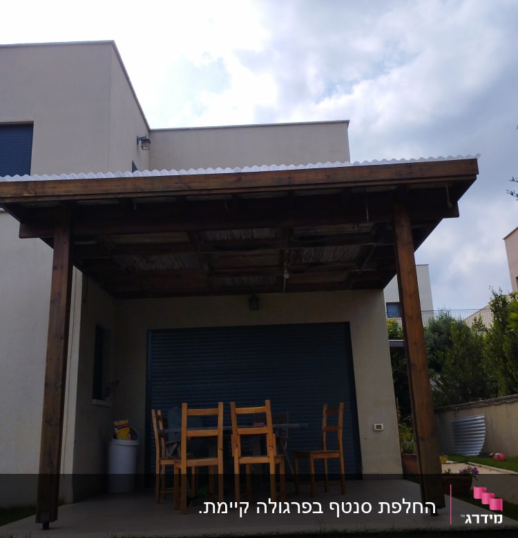 פרגולה מעץ עם שולחן וכיסאות בגינה